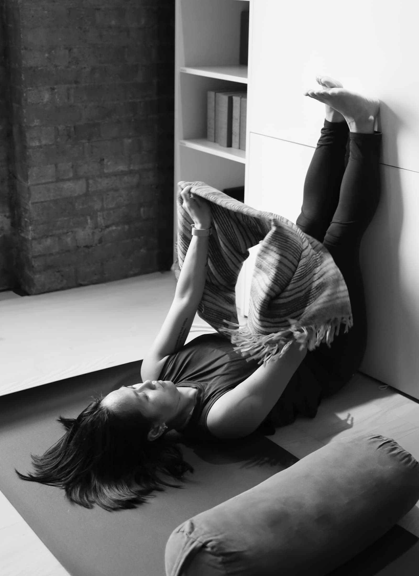 Student of Trauma Informed Yoga Teacher Training practicing during the course using a wall as props