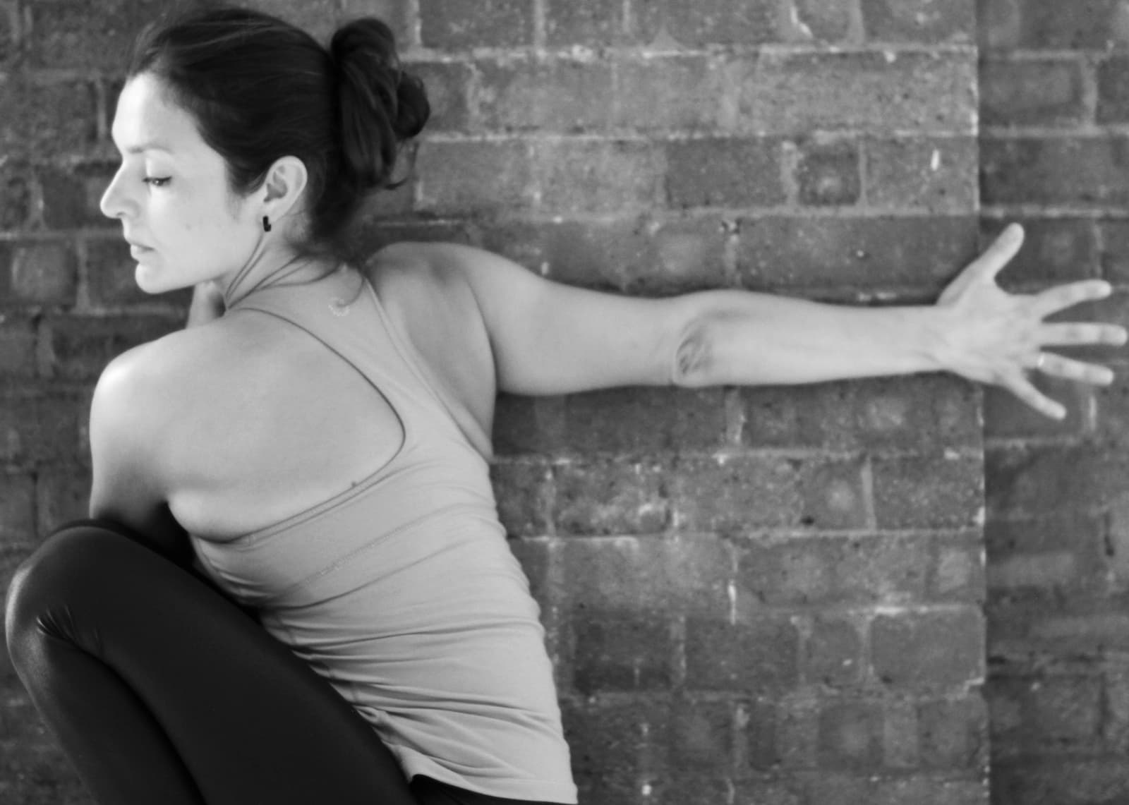 Teacher using the Wall as a Prop to open the shoulders on 300-hour teacher training course