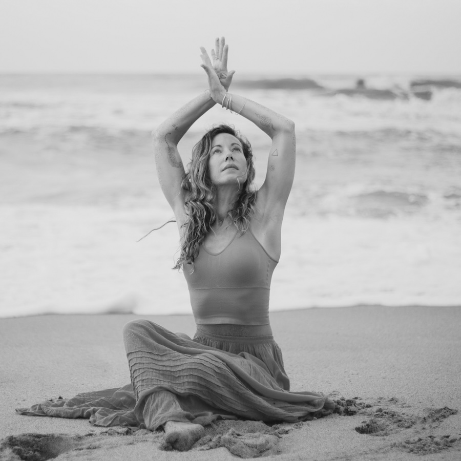 Emma Landolt practicing yoga on a sandy beach