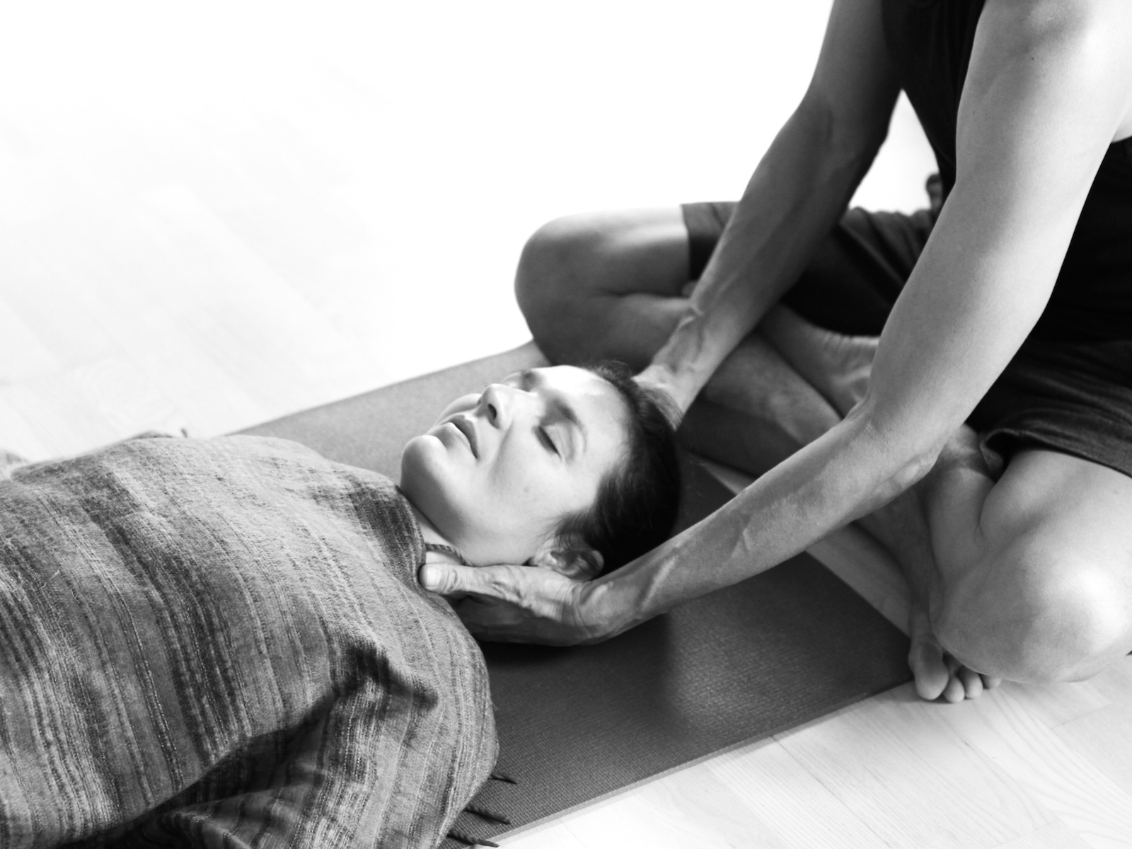 Shivasana handds-on assist on a yoga teacher training course at the Shala