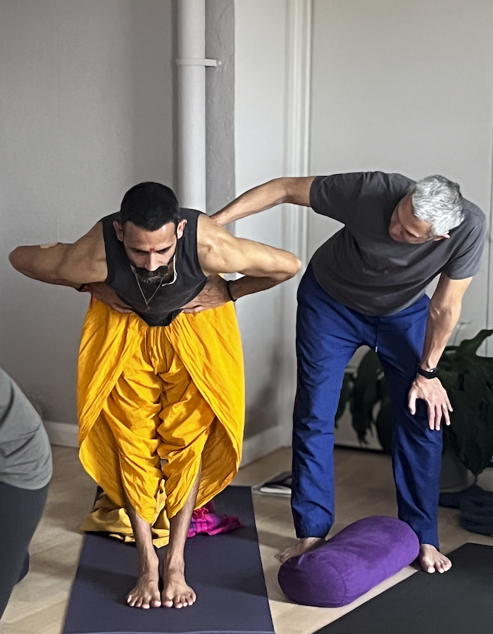 Gingi Lee demonstrating a hands on assist during a 200 hour teacher training course session