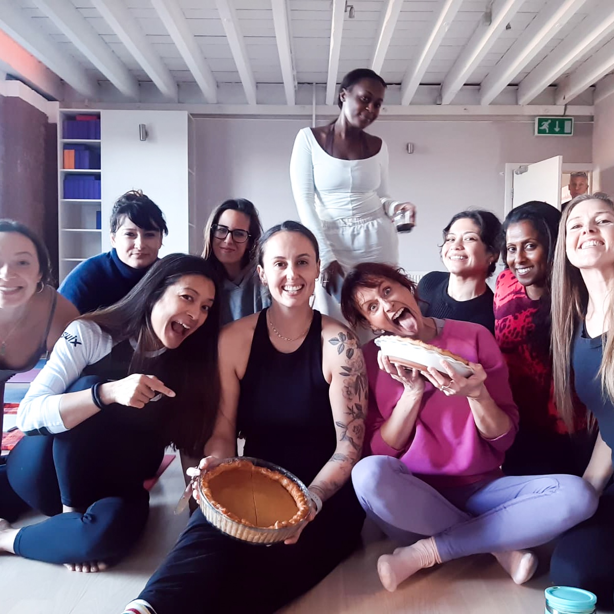 Group shot of 200-hour students with a Pumpkin Pie baked by a student